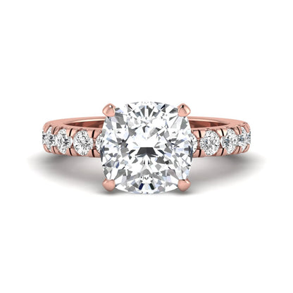 Cushion cut lab grown diamond solitaire engagement ring featuring a four-prong setting with a shared prong round diamond band in a rose gold tone design.