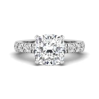 Cushion cut lab grown diamond solitaire engagement ring featuring a four-prong setting with a shared prong round diamond band in a white gold tone design.