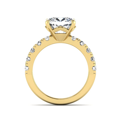 Cushion cut lab grown diamond solitaire engagement ring featuring a four-prong setting with a shared prong round diamond band in a yellow gold tone design.