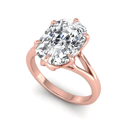 Elongated cushion cut lab grown diamond solitaire engagement ring featuring a four-prong setting with a split cathedral shank in a rose gold tone design.