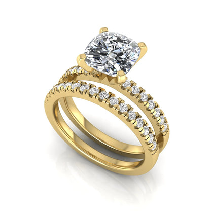 Cushion cut lab grown diamond solitaire engagement ring with matching pavé diamond wedding band in yellow gold.