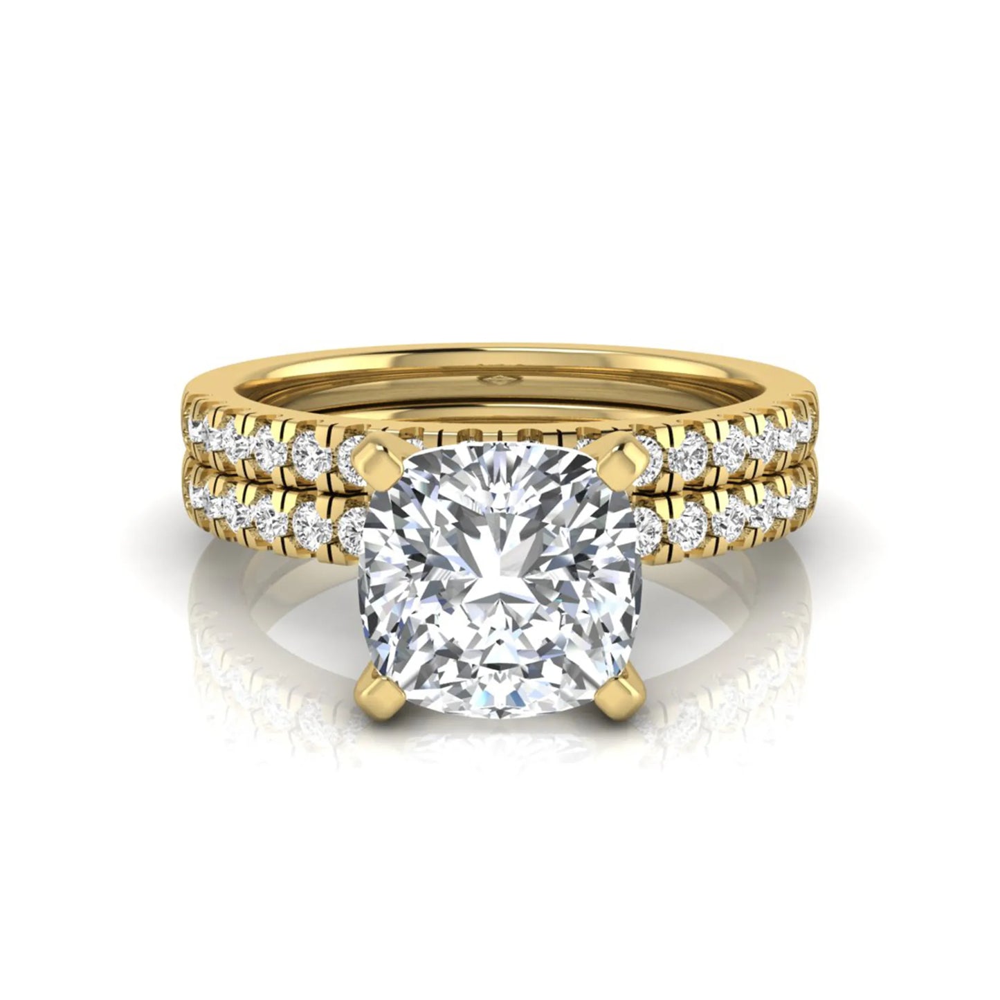 Cushion cut lab grown diamond solitaire engagement ring with matching pavé diamond wedding band in yellow gold.