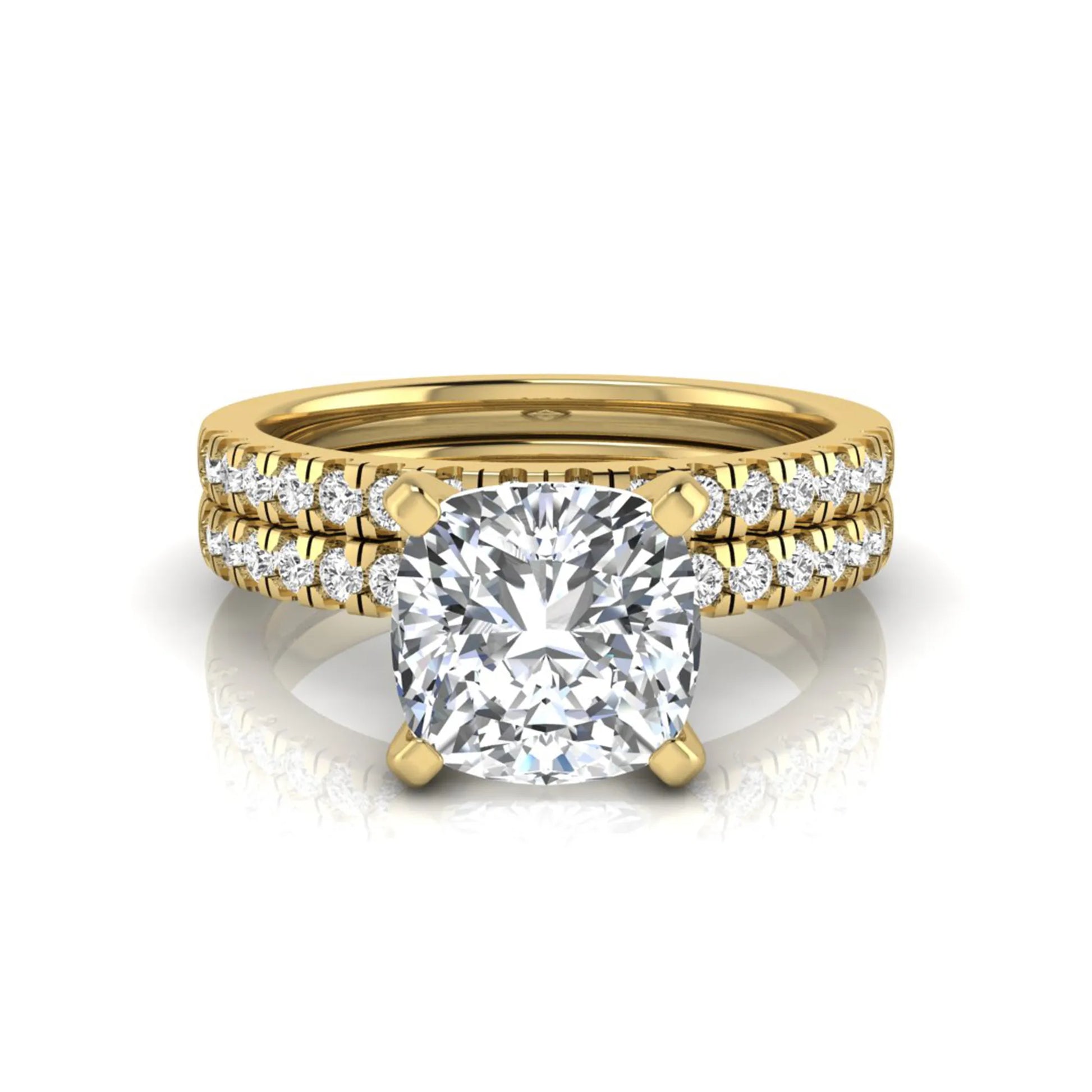 Cushion cut lab grown diamond solitaire engagement ring with matching pavé diamond wedding band in yellow gold.