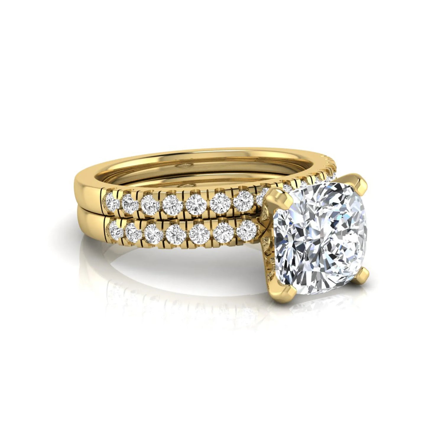 Cushion cut lab grown diamond solitaire engagement ring with matching pavé diamond wedding band in yellow gold.