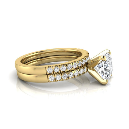 Cushion cut lab grown diamond solitaire engagement ring with matching pavé diamond wedding band in yellow gold.