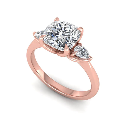 Cushion cut three stone lab grown diamond engagement ring featuring a 1.67 carat IGI certified center diamond with pear side diamonds in rose gold.
