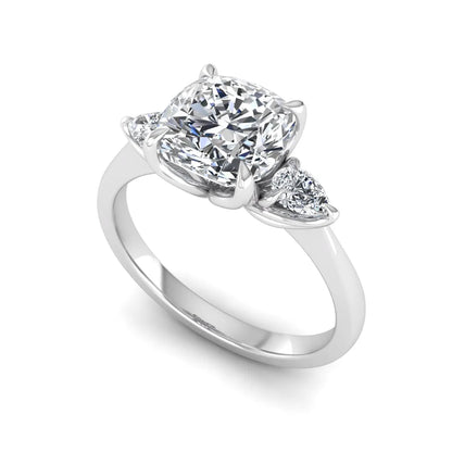 Cushion cut three stone lab grown diamond engagement ring featuring a 1.67 carat IGI certified center diamond with pear side diamonds in white gold.