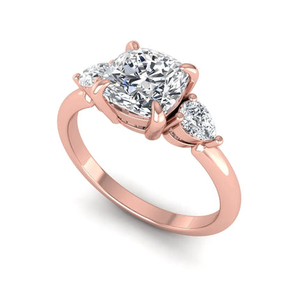 Cushion cut lab grown diamond three stone engagement ring with pear cut side diamonds in a classic prong setting in rose gold