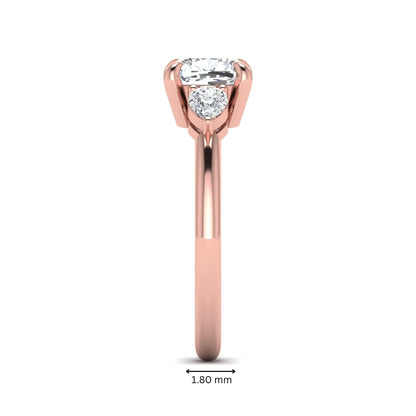 Cushion cut lab grown diamond three stone engagement ring with pear cut side diamonds in a classic prong setting in rose gold