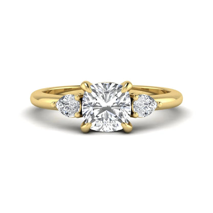 Cushion cut lab grown diamond three stone engagement ring with pear cut side diamonds in a classic prong setting in yellow gold