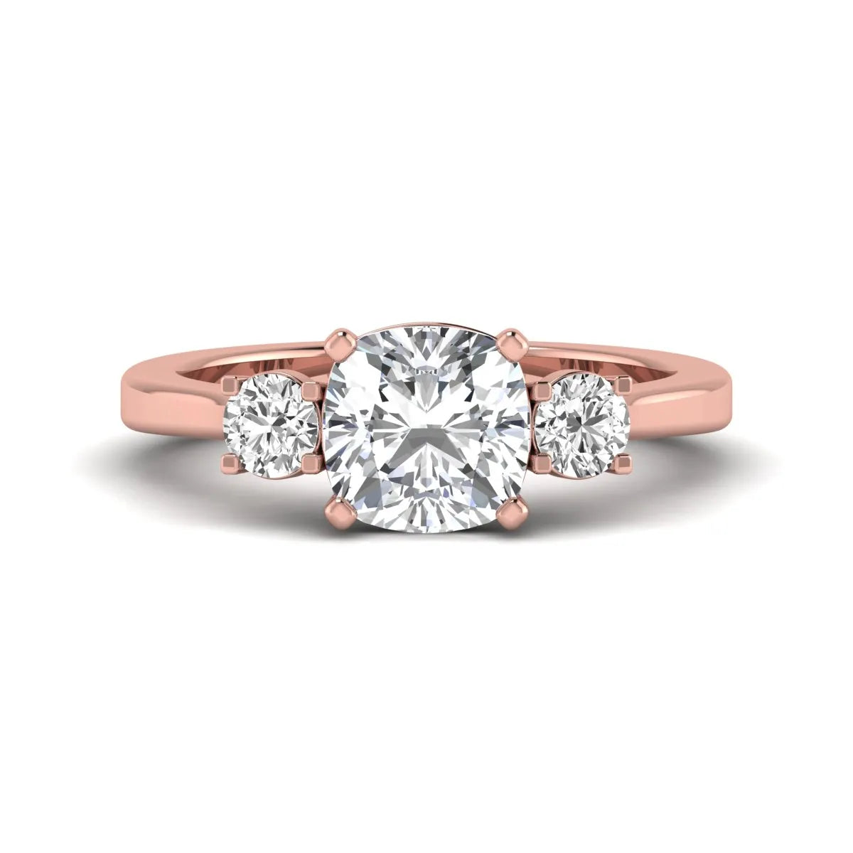 Cushion cut lab grown diamond three stone engagement ring featuring a cushion center diamond with round brilliant side diamonds on a polished rose gold band.