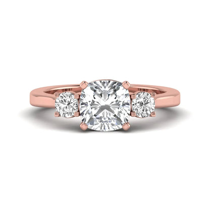 Cushion cut lab grown diamond three stone engagement ring featuring a cushion center diamond with round brilliant side diamonds on a polished rose gold band.