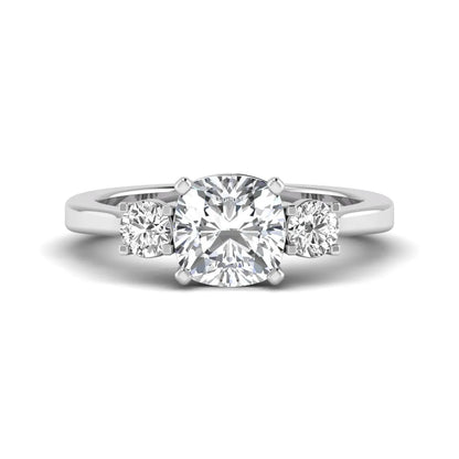 Cushion cut lab grown diamond three stone engagement ring featuring a cushion center diamond with round brilliant side diamonds on a polished white gold band.