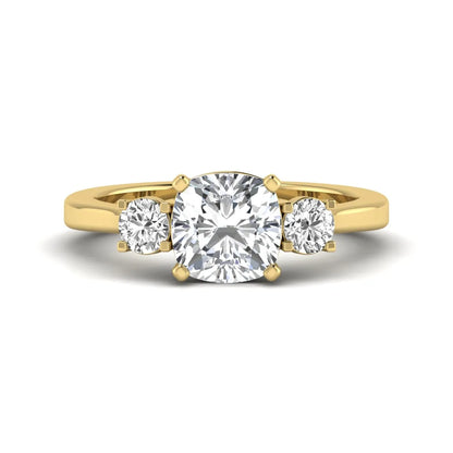 Cushion cut lab grown diamond three stone engagement ring featuring a cushion center diamond with round brilliant side diamonds on a polished yellow gold band.