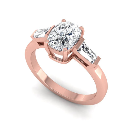 Cushion cut lab grown diamond three stone engagement ring with baguette side diamonds in a four prong setting and rose gold tone band.