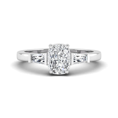 Cushion cut lab grown diamond three stone engagement ring with baguette side diamonds in a four prong setting and white gold tone band.