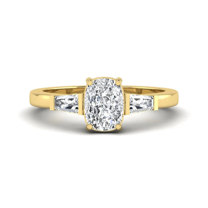 Cushion cut lab grown diamond three stone engagement ring with baguette side diamonds in a four prong setting and yellow gold tone band.