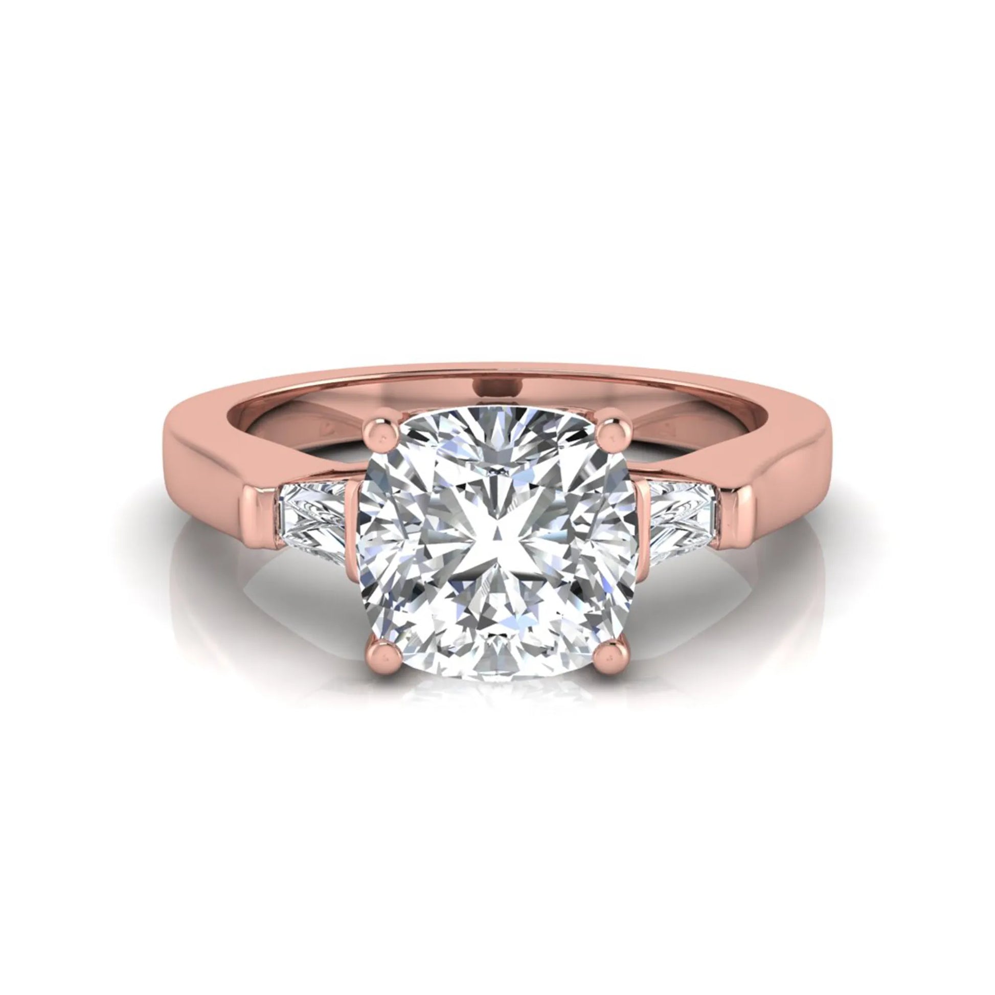 Cushion cut lab grown diamond three stone engagement ring featuring tapered baguette side diamonds in a four prong setting with yellow gold finish. in rose gold
