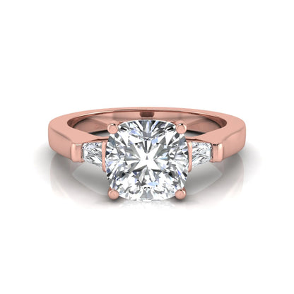Cushion cut lab grown diamond three stone engagement ring featuring tapered baguette side diamonds in a four prong setting with yellow gold finish. in rose gold