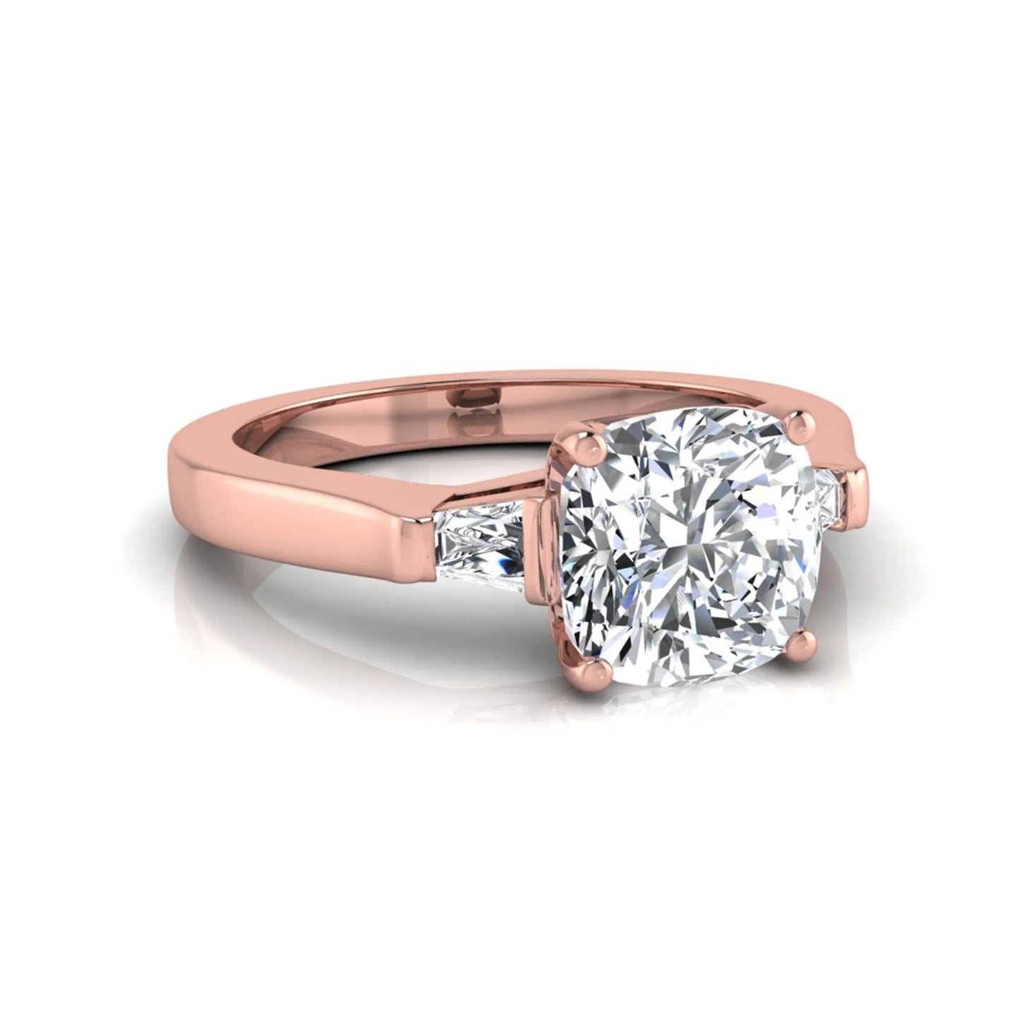 Cushion cut lab grown diamond three stone engagement ring featuring tapered baguette side diamonds in a four prong setting with yellow gold finish. in rose gold