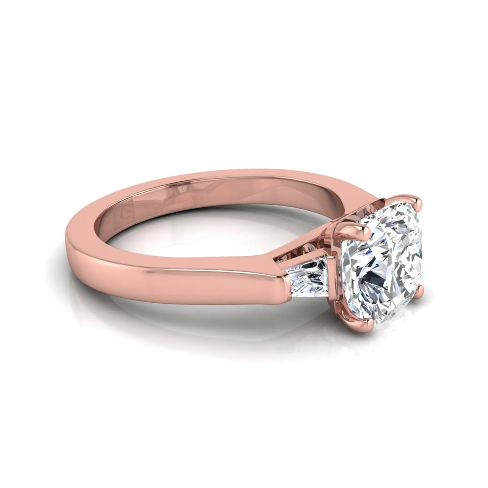 Cushion cut lab grown diamond three stone engagement ring featuring tapered baguette side diamonds in a four prong setting with yellow gold finish. in rose gold