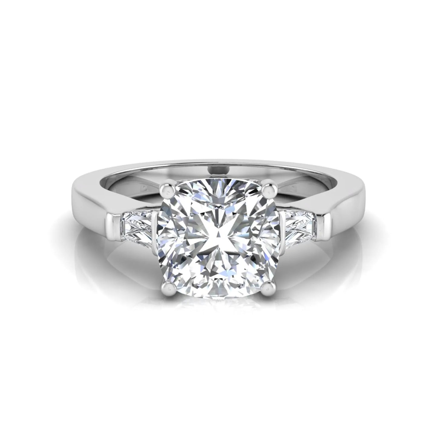 Cushion cut lab grown diamond three stone engagement ring featuring tapered baguette side diamonds in a four prong setting with yellow gold finish. in white gold