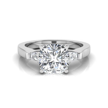 Cushion cut lab grown diamond three stone engagement ring featuring tapered baguette side diamonds in a four prong setting with yellow gold finish. in white gold