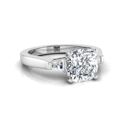 Cushion cut lab grown diamond three stone engagement ring featuring tapered baguette side diamonds in a four prong setting with yellow gold finish. in white gold