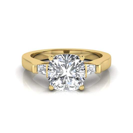 Cushion cut lab grown diamond three stone engagement ring featuring tapered baguette side diamonds in a four prong setting with yellow gold finish. in yellow gold
