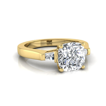 Cushion cut lab grown diamond three stone engagement ring featuring tapered baguette side diamonds in a four prong setting with yellow gold finish. in yellow gold