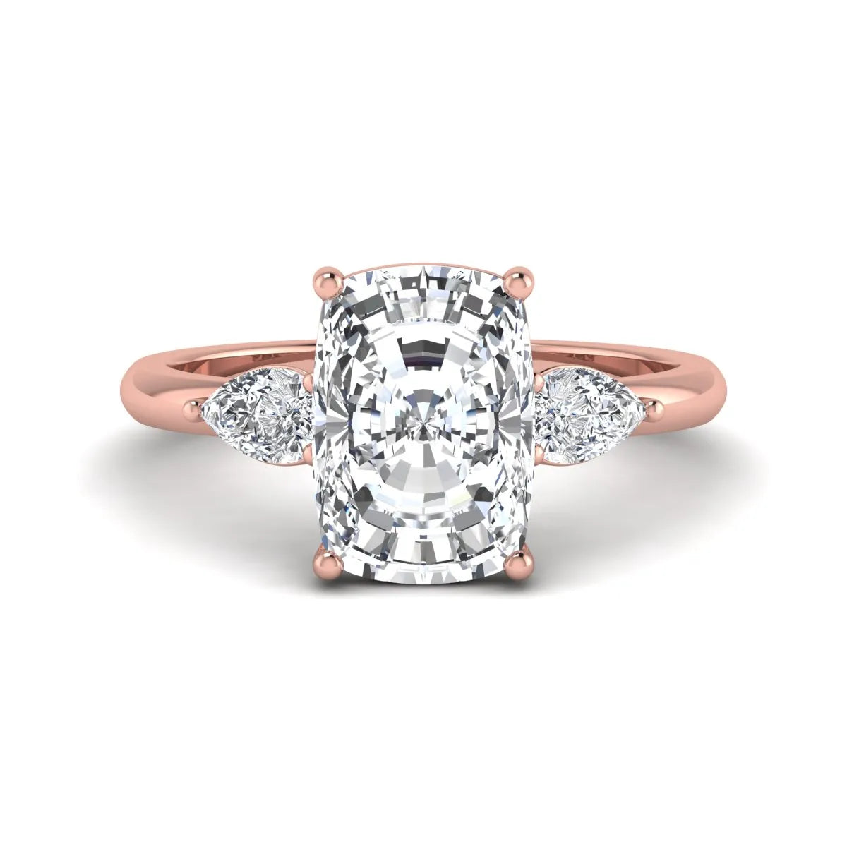 Elongated cushion cut lab grown diamond three stone engagement ring featuring pear cut side diamonds in a four-prong setting with a polished rose gold tone band.