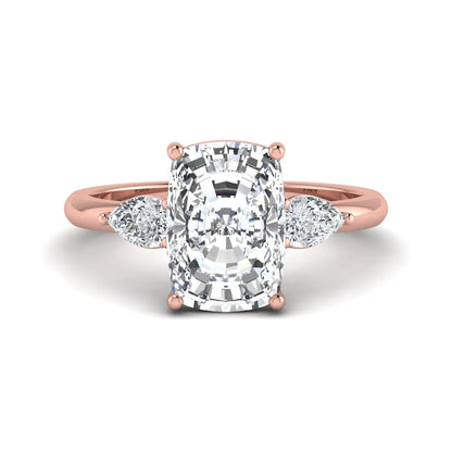 Elongated cushion cut lab grown diamond three stone engagement ring featuring pear cut side diamonds in a four-prong setting with a polished rose gold tone band.