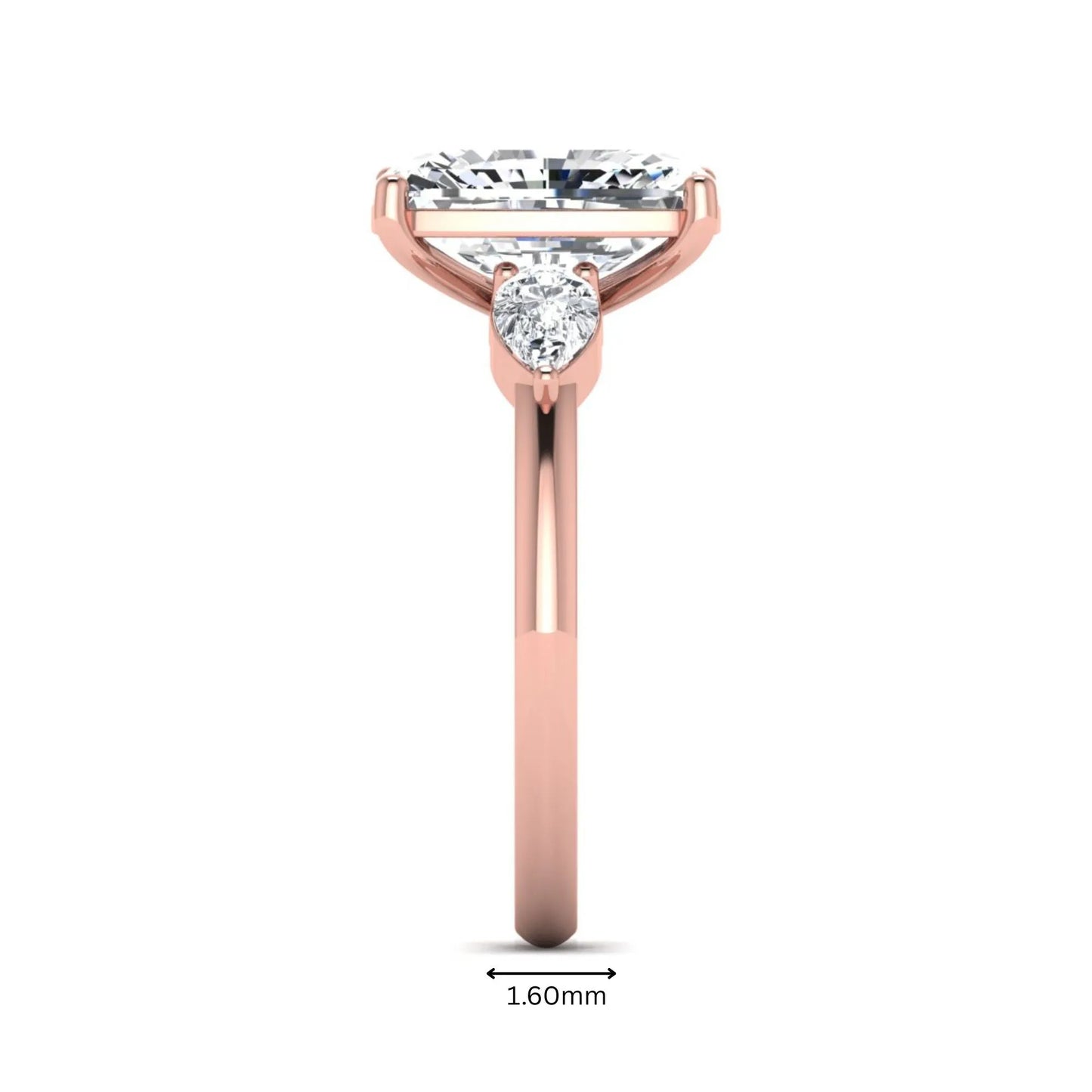 Elongated cushion cut lab grown diamond three stone engagement ring featuring pear cut side diamonds in a four-prong setting with a polished rose gold tone band.
