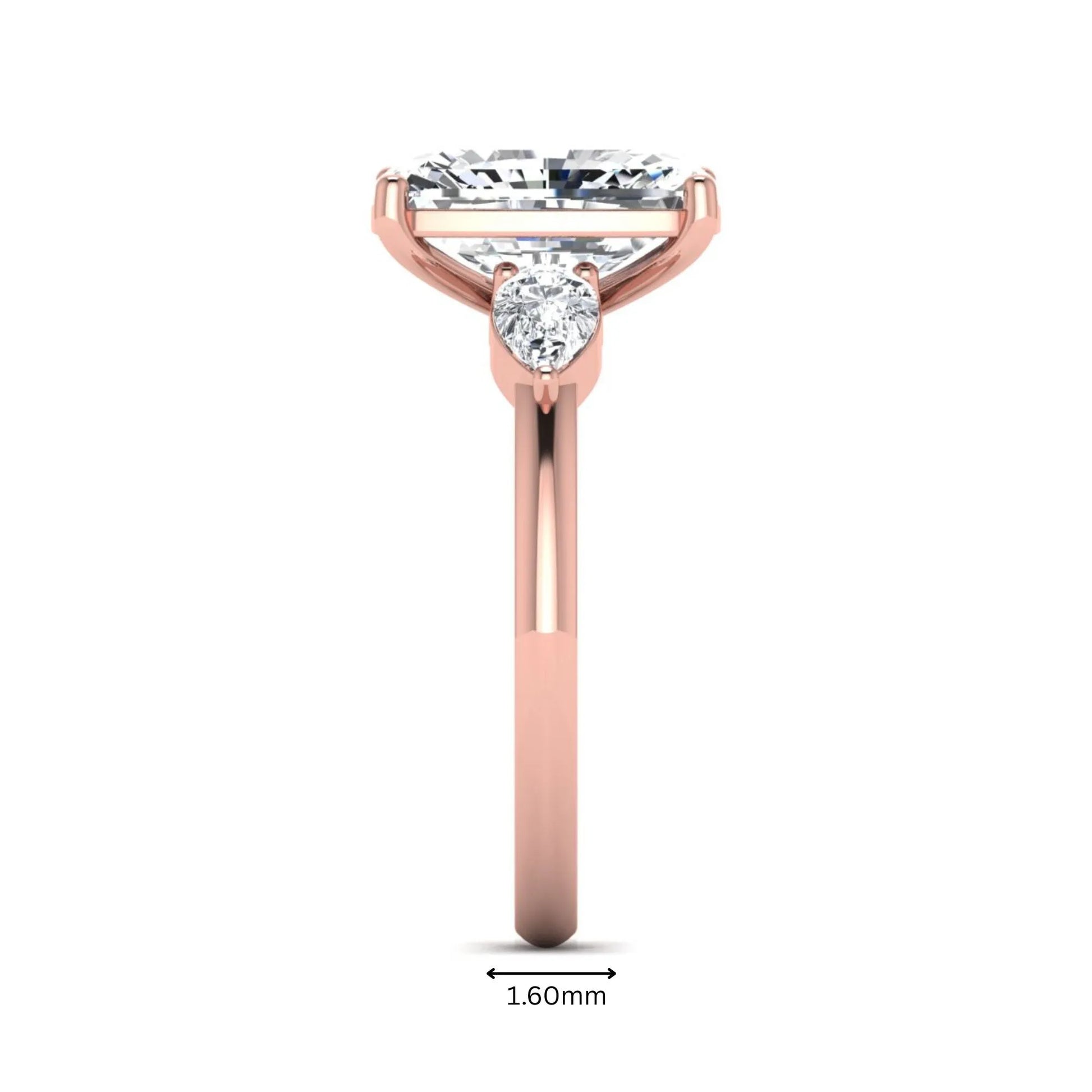 Elongated cushion cut lab grown diamond three stone engagement ring featuring pear cut side diamonds in a four-prong setting with a polished rose gold tone band.