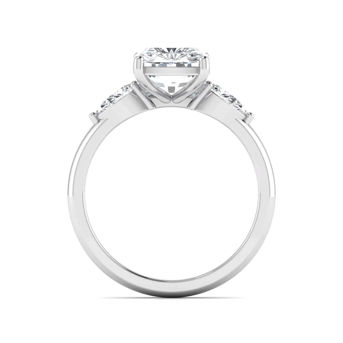 Elongated cushion cut lab grown diamond three stone engagement ring featuring pear cut side diamonds in a four-prong setting with a polished white gold tone band.