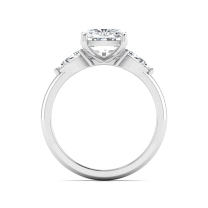 Elongated cushion cut lab grown diamond three stone engagement ring featuring pear cut side diamonds in a four-prong setting with a polished white gold tone band.