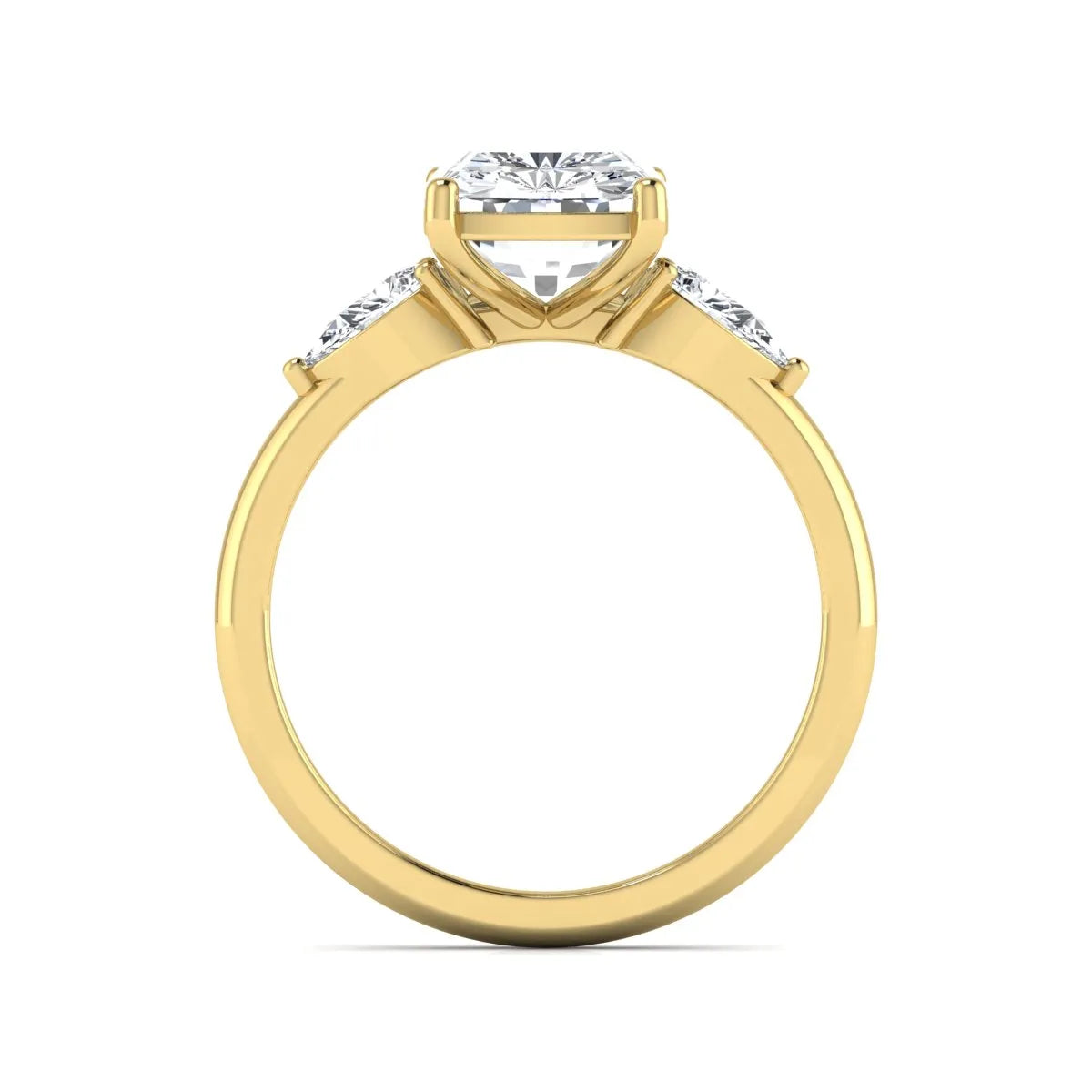 Elongated cushion cut lab grown diamond three stone engagement ring featuring pear cut side diamonds in a four-prong setting with a polished yellow gold tone band.