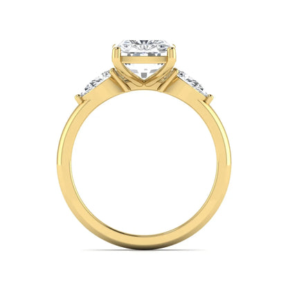 Elongated cushion cut lab grown diamond three stone engagement ring featuring pear cut side diamonds in a four-prong setting with a polished yellow gold tone band.