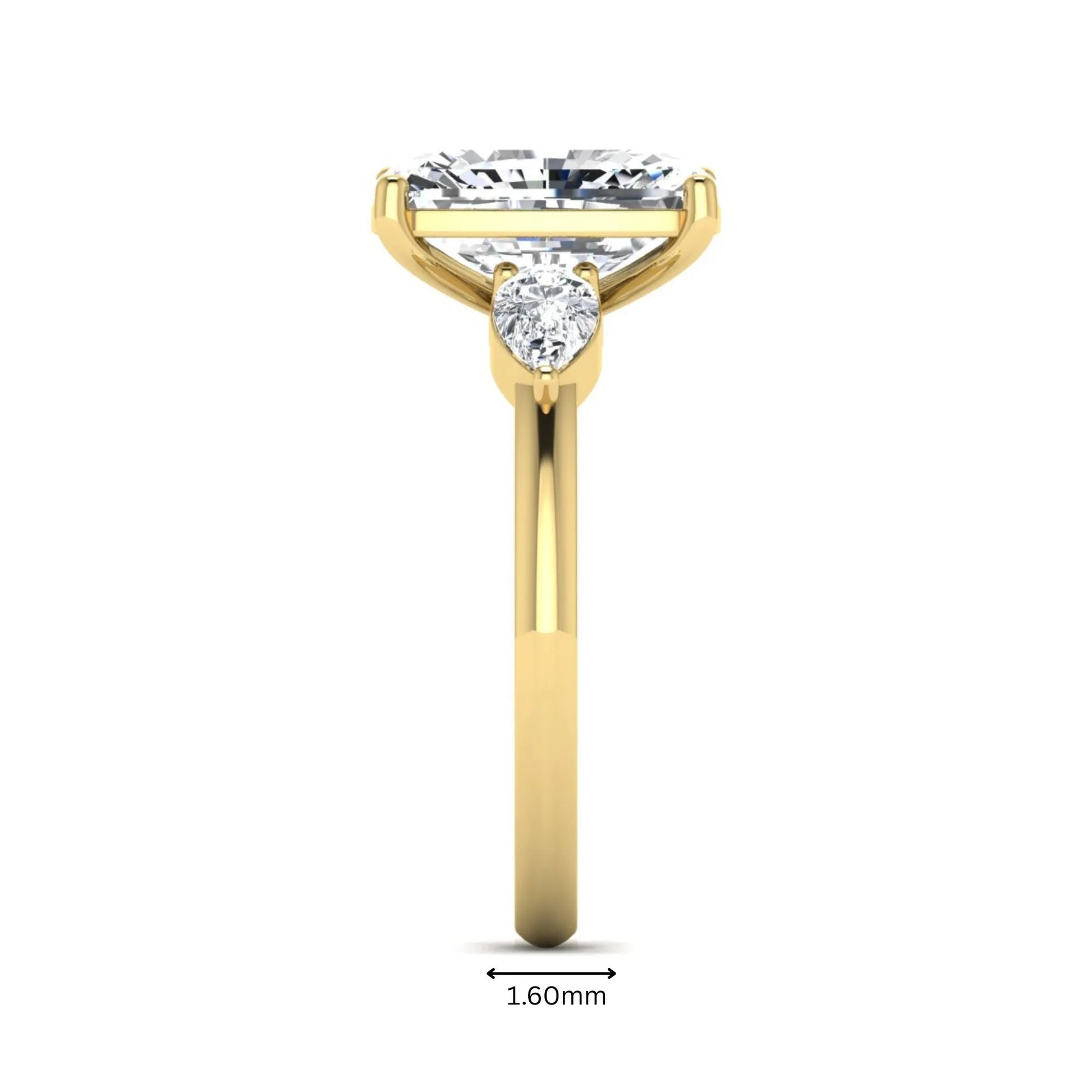Elongated cushion cut lab grown diamond three stone engagement ring featuring pear cut side diamonds in a four-prong setting with a polished yellow gold tone band.