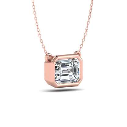 Emerald cut lab grown diamond solitaire pendant necklace with a modern bezel setting in a polished rose gold metal finish.