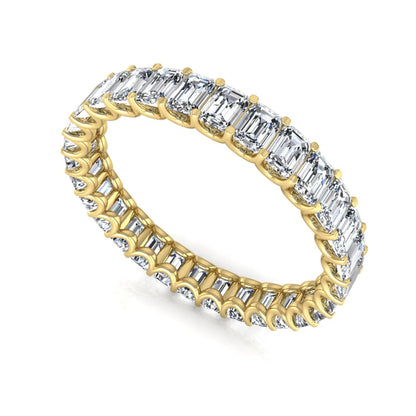 Emerald cut lab grown diamond eternity band featuring a continuous row of shared prong set diamonds in a timeless luxury design in yellow gold