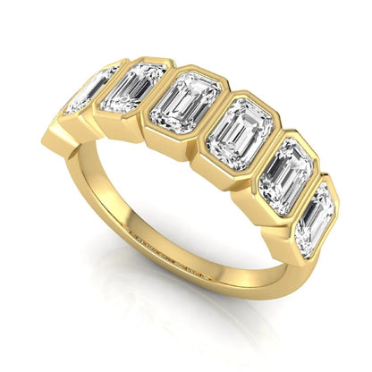 Emerald cut lab grown diamond bezel seven stone band featuring 2.03 carats of bezel set emerald diamonds in yellow gold.