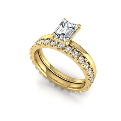 Emerald cut lab grown diamond bridal ring set featuring a 1.06 carat IGI certified center diamond with a matching round diamond wedding band in yellow gold.