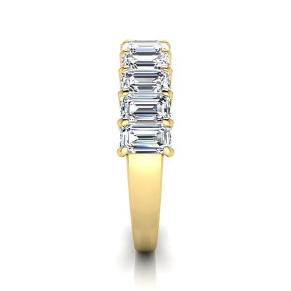 Emerald cut lab grown diamond half eternity band featuring shared prong set diamonds in a yellow gold tone finish.
