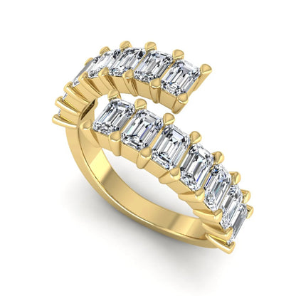 Emerald cut lab grown diamond open cuff bypass ring with prong setting in yellow gold tone.