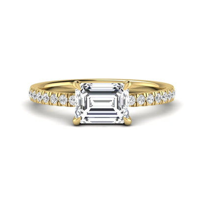 Emerald cut lab grown diamond solitaire pavé engagement ring with four-prong setting and yellow gold tone band.