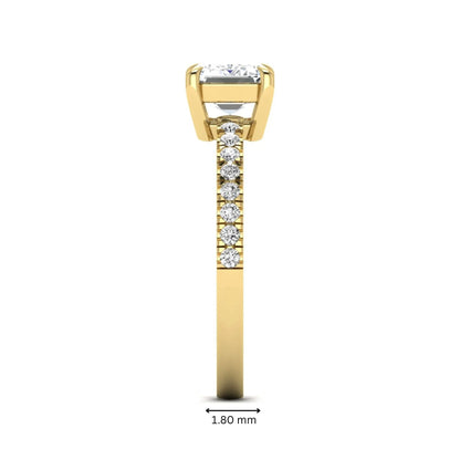 Emerald cut lab grown diamond solitaire pavé engagement ring with four-prong setting and yellow gold tone band.