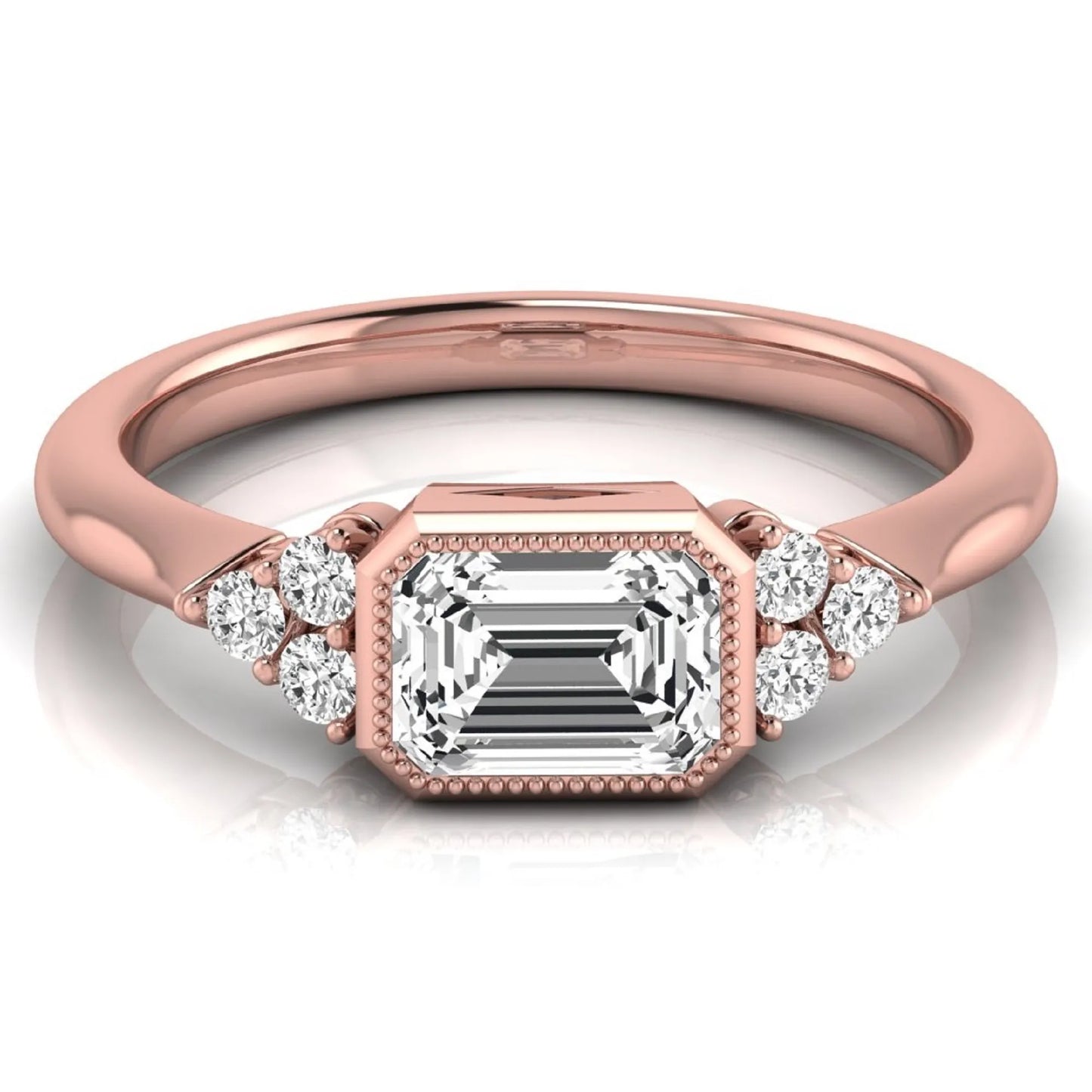 Emerald cut lab grown diamond engagement ring featuring a milgrain bezel setting with round side stone clusters in rose gold.