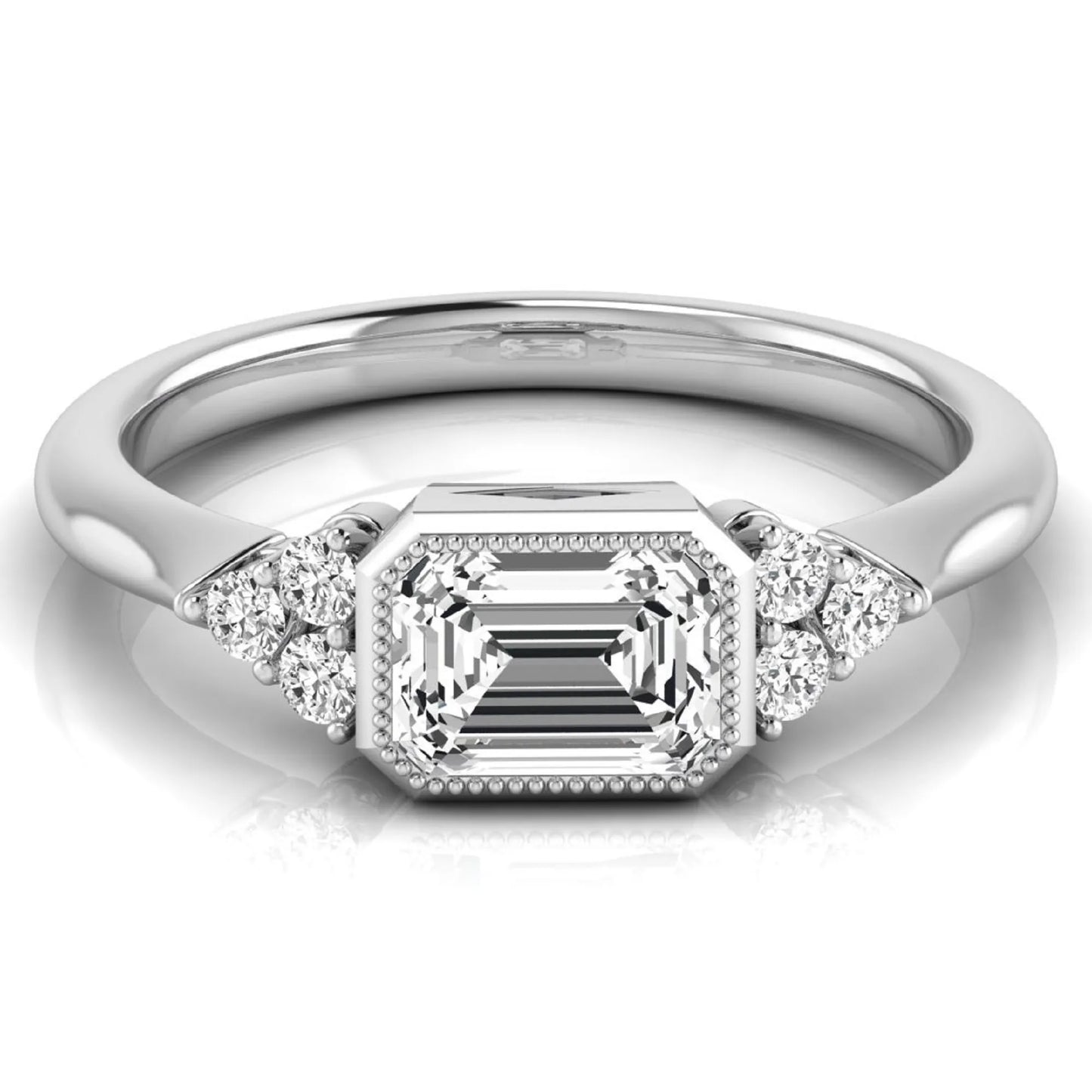 Emerald cut lab grown diamond engagement ring featuring a milgrain bezel setting with round side stone clusters in white gold.