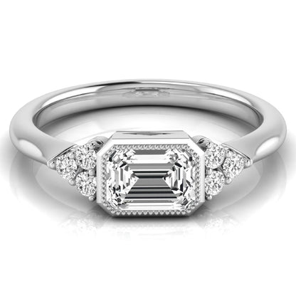 Emerald cut lab grown diamond engagement ring featuring a milgrain bezel setting with round side stone clusters in white gold.